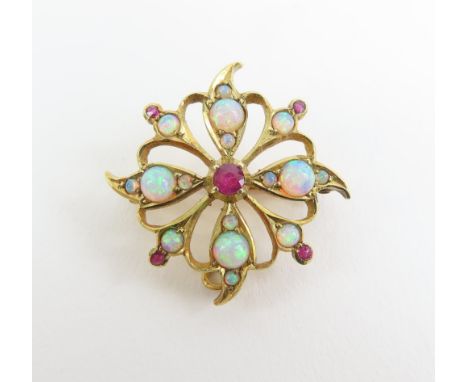 An early to mid 20th century opal and ruby brooch, in an open work floral design, with hanging loop so that it can also be wo