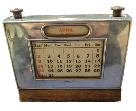 A silver desk calendar, by W J Myatt & Co, Birmingham, 1929, rectangular form with central day/date window, 10cm high