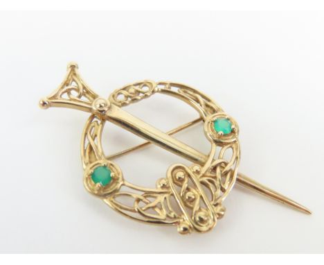 A 9ct gold Celtic Ardagh brooch, set with two round emeralds, 4.7cm x 4cm (max), 4.3g gross
