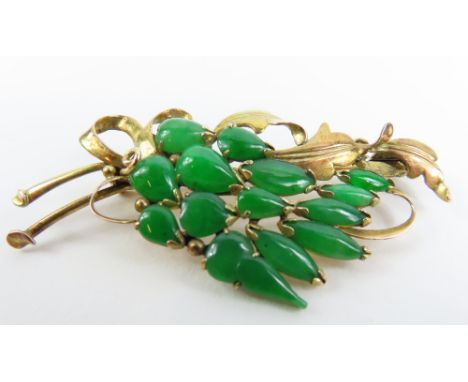 A dyed jade set brooch, in a stylised bouquet shape, marked '14k', 5.5cm long, 6.4g gross