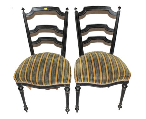 A pair of 19th century lacquered dining or drawing room chairs with ladder back supports, finials to the uprights, fabric uph