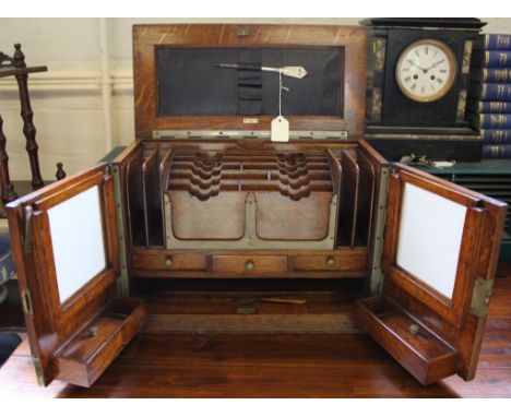 An Army & Navy GSL made early 20th century oak stained stationery box with lift up lid, fitted interior with three drawers un
