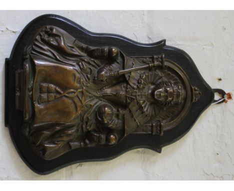 A Victorian bronze plaque mounted on a wooden base of a seated queen holding a sceptre and globe, 35cm long