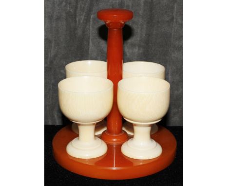 Four ivory egg cups on a catalin stand, 13.5cm  The Art Deco Carvings of W. G. Collins (1872-1959) Worshipful Company of Turn