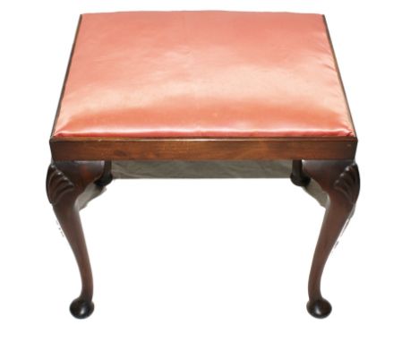A Georgian-style oblong mahogany framed dressing stool with silk upholstered seat, carved shell scrolls to the knees, on cabr