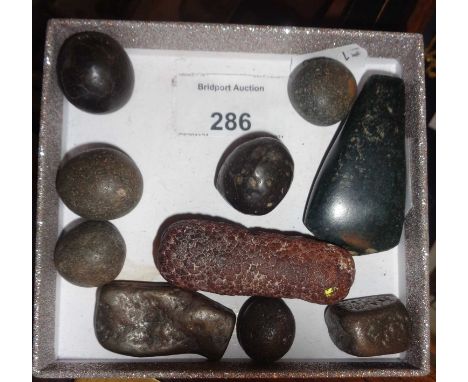 Carved stone axe head, and a fossil coprolite, with other stones