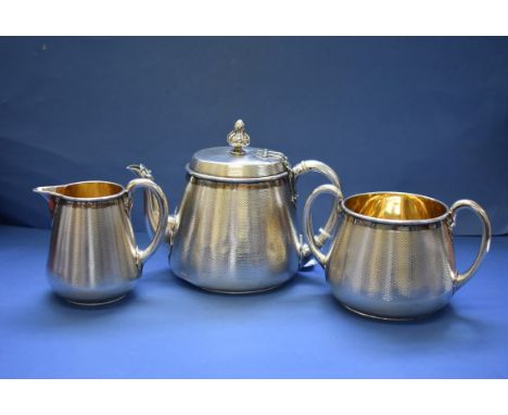 A Victorian silver engine turned three piece tea set,&nbsp;by John Samuel Hunt,&nbsp;London 1860 &amp; 1861, having gilt lini