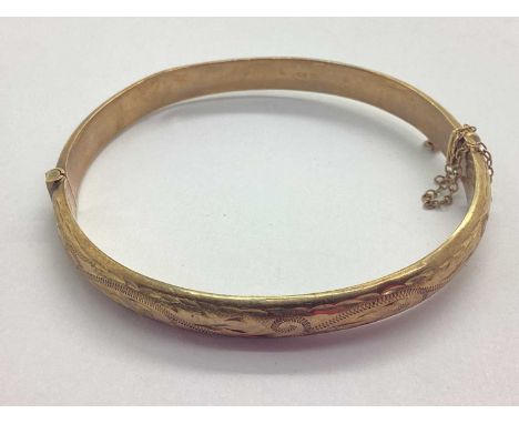 A Vintage 9ct Gold Hinged Bangle, with scrolling foliage design to front, safety clasp damaged, approximately 5.5cm diameter 