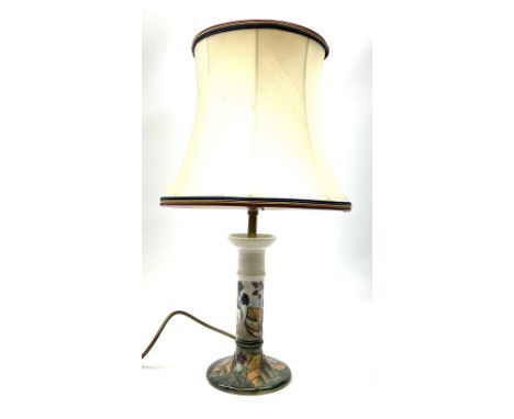 A Moorcroft table lamp, of candle stick form, decorated in the Blackberry and Leaves pattern upon a light blue ground, with i