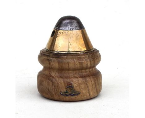 A WW1 trench art fuse mounted on a turned hardwood base paperweight with applied gilt and enamel Royal Artillery badge. Overa