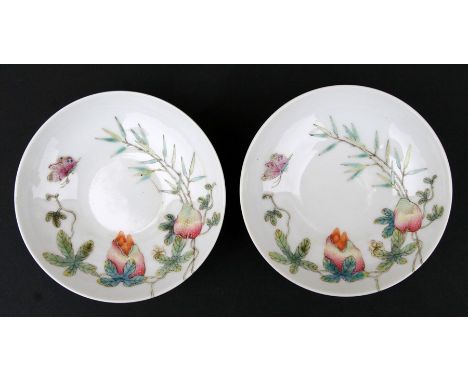 A pair of Chinese famille rose footed dishes decorated with fruit and butterflies, red seal mark to the underside, 11cms (4.2