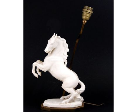 A ceramic table lamp in the form of a rearing horse, on a gilt metal base, 33cms (13ins) high.