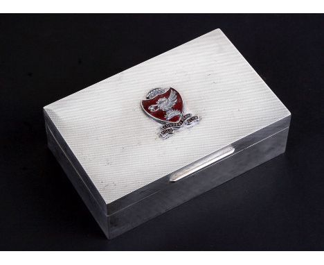 An Asprey silver table top cigarette box mounted with an enamel crest for the Cowdray Park Polo Club, 14cms (5.5ins) wide.