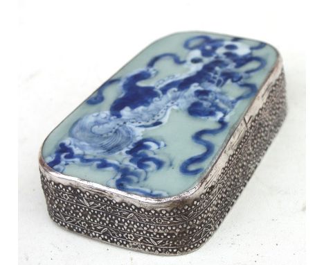 A 19th century Chinese white metal and ceramic fragment box, the celadon glazed cover painted with blue &amp; white images of