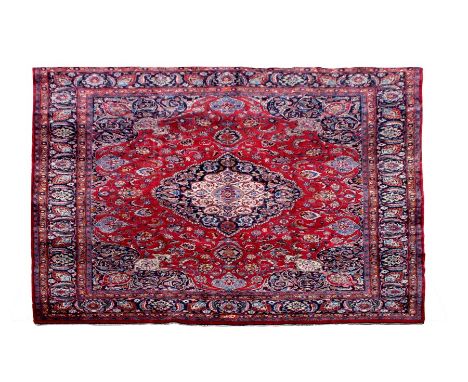 A Persian Mashad woollen hand knotted carpet with central floral medallion within floral borders on a beige ground, 380 by 29