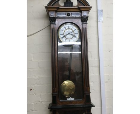 A mahogany Vienna wall clock with double weights and visible pendulum