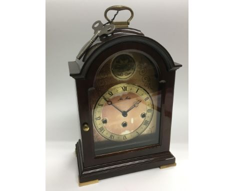A modern mahogany arch topped mantle clock, approx 31.5cm.