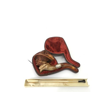A cased, silver mounted and amber Meersham pipe with carved figural bowl, a/f, plus a cigarette holder