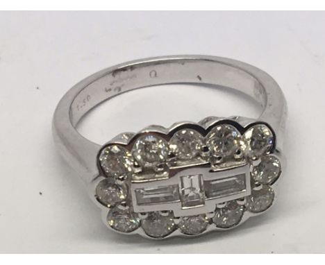 A modern design 18carat white gold ring set with three central baguette diamonds flanked by brilliant cut diamonds. Ring size