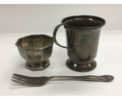 Three silver items comprising a mug, small dish and a fork.