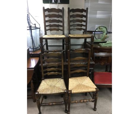 A set of four rush seated ladder back chairs.