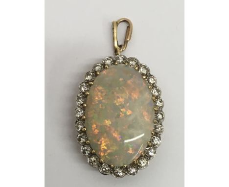 A fine quality,  opal and diamond surround oval pendant drop with pierced gold back.Approx 3.5cm long