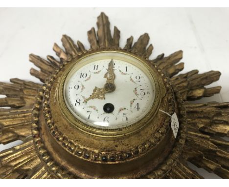 A sunburst wall clock the enamel dial with Arabic numerals