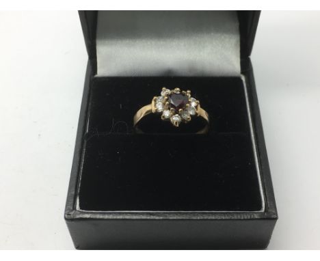 A 9ct gold ring with a central heart shaped red stone surrounded by CZs, approx 1.3g and approx size M-N.