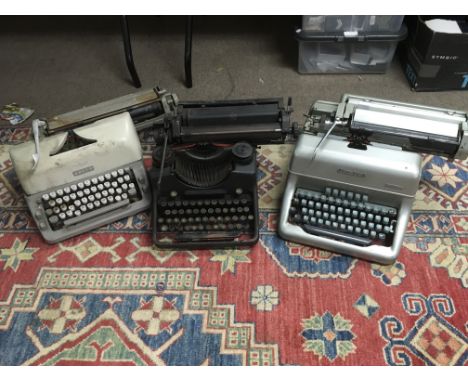 Three vintage typewriters, a Singer sewing machine and an old radio (5).