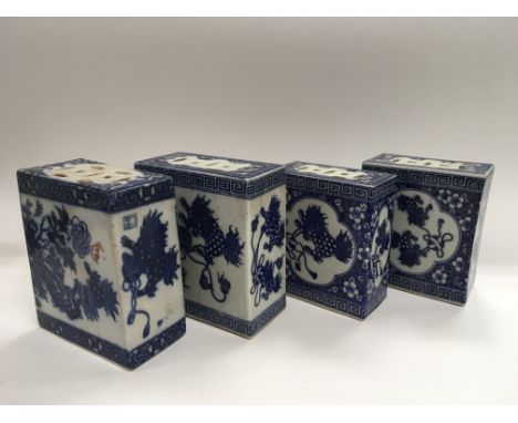 Four blue and white ceramic hand warmers of squared form, each one approx 15cm high.
