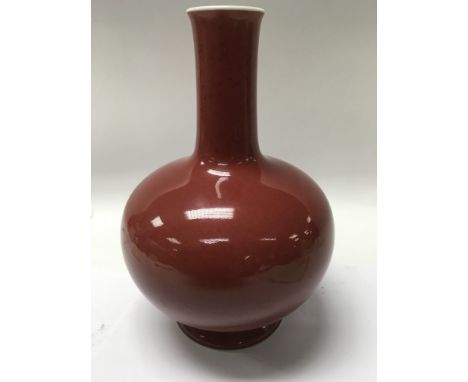 A Chinese bottle vase having a red glaze and seal mark to base 24 cm