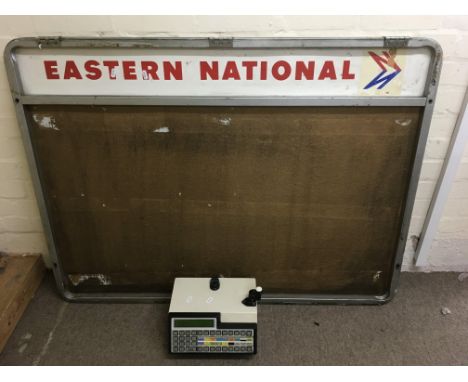 A very large Eastern National bus noticeboard with an accompanying ticket machine.Approx 91x119cm