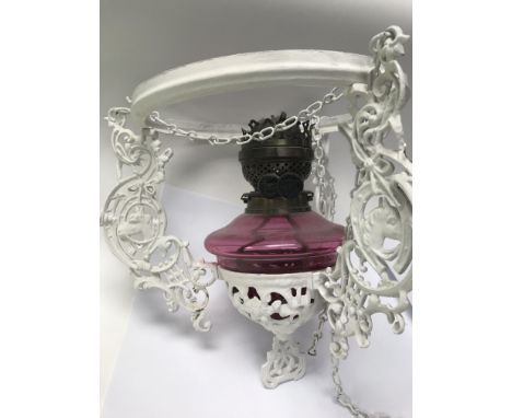 A hanging Victorian cranberry oil lamp with glass shade
