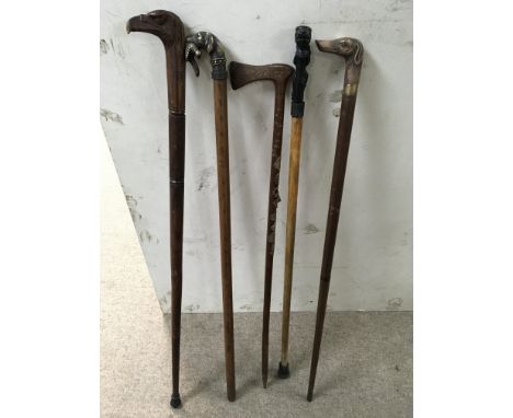 A walking stick with carved eagles head, Alpine walkers stick with brass badges and three walking sticks with metal heads