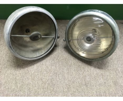 A pair vintage Jaguar car sports headlights, one lacking glass