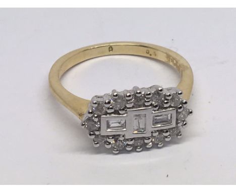 An 18carT gold ring set with a pattern of diamonds with three baguette diamonds flanked by further diamonds. 0.50 carat. Ring