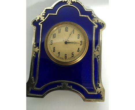 A silver and enamel desk clock by Charles and Richard Comyns , London, of strut form the arched shape frame with leaf detail 