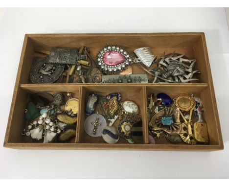 A tray containing approximately fifty metal pendants including enamel