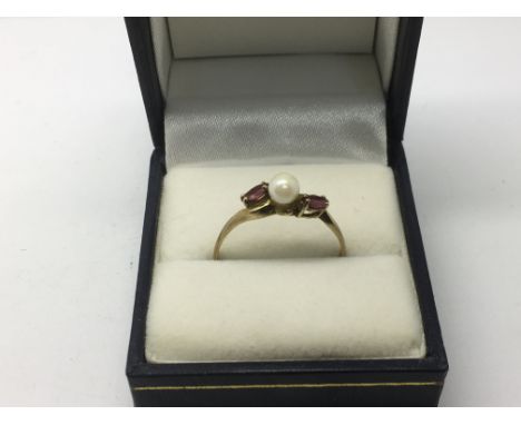 A 9ct gold ring set with a central pearl  and two garnets, approx 1.6g and approx size V.