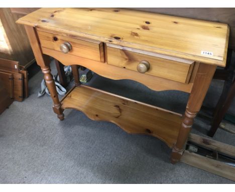 A pine side table with two drawers on turned legs united by an under shelf