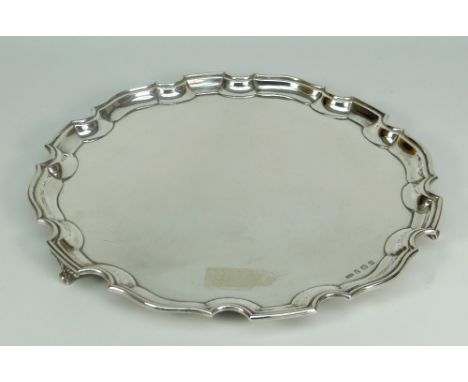 GEORGE V SILVER SALVER having pie crust edge raised on three scroll-type feet, Birmingham 1932, makers initials C &amp; K, 27