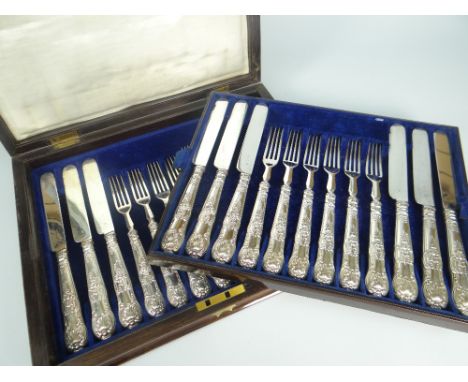 CASED TWELVE-PIECE DESSERT KNIFE &amp; FORK SET having silver handles with scroll and shell decoration, in fitted box with br