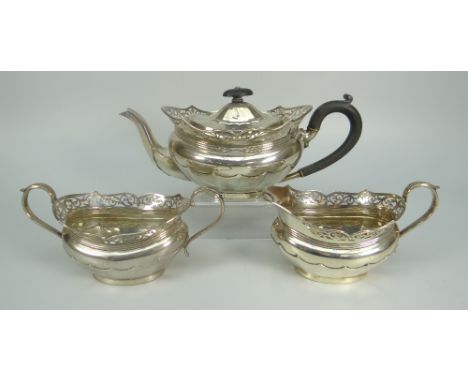 GEORGE V THREE-PIECE SILVER TEASET comprising teapot, sucrier and cream jug, all with pierced scroll design rims, maker's mar