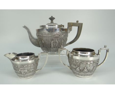 AN INDIAN STERLING SILVER THREE-PIECE TEASET comprising teapot, sucrier and cream jug, overall decorated with farming scenes 