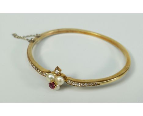 YELLOW METAL DIAMOND, RUBY AND PEARL BANGLE the stones arranged depicting the playing suit of 'Clubs'. 10 grams approximately