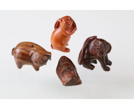 Four miniature carved wood netsuke figures to include pig, rabbit, old mans head and signed big cat