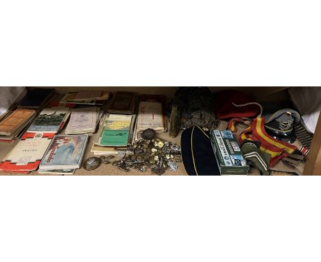 A large collection of military cap badges and buttons together with a helmet, military hats, shell cases, epaulettes, maps et