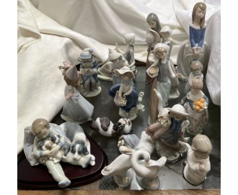 A collection of Lladro and Nao figures including a boy cuddling puppies, a panda, geese, young ladies etc 