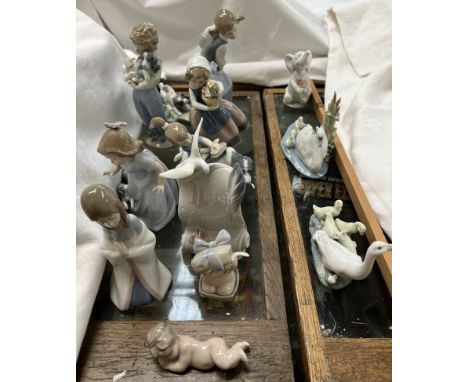 A collection of Lladro and Nao figures including an elephant, swan and cygnets, goose and goslings, cherub, children with dog