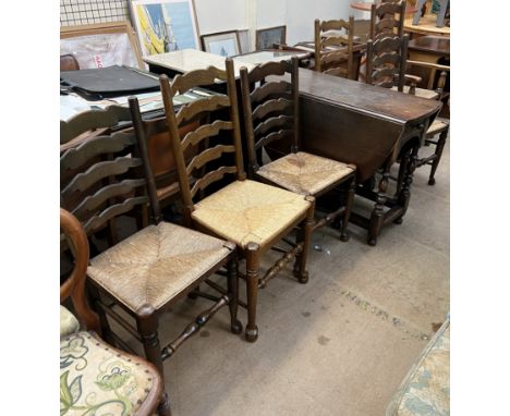 A 20th century oak gateleg dining table together with a set of seven ladder back dining chairs 